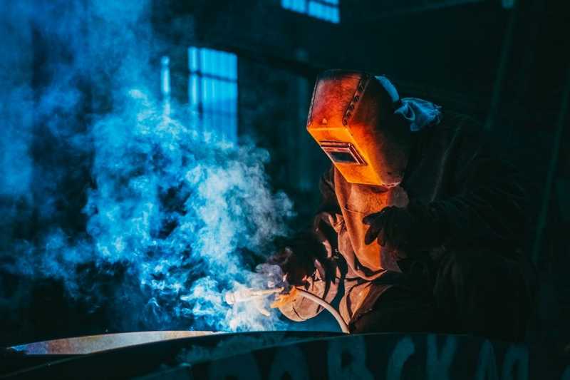Person welding wearing a protective metal mask